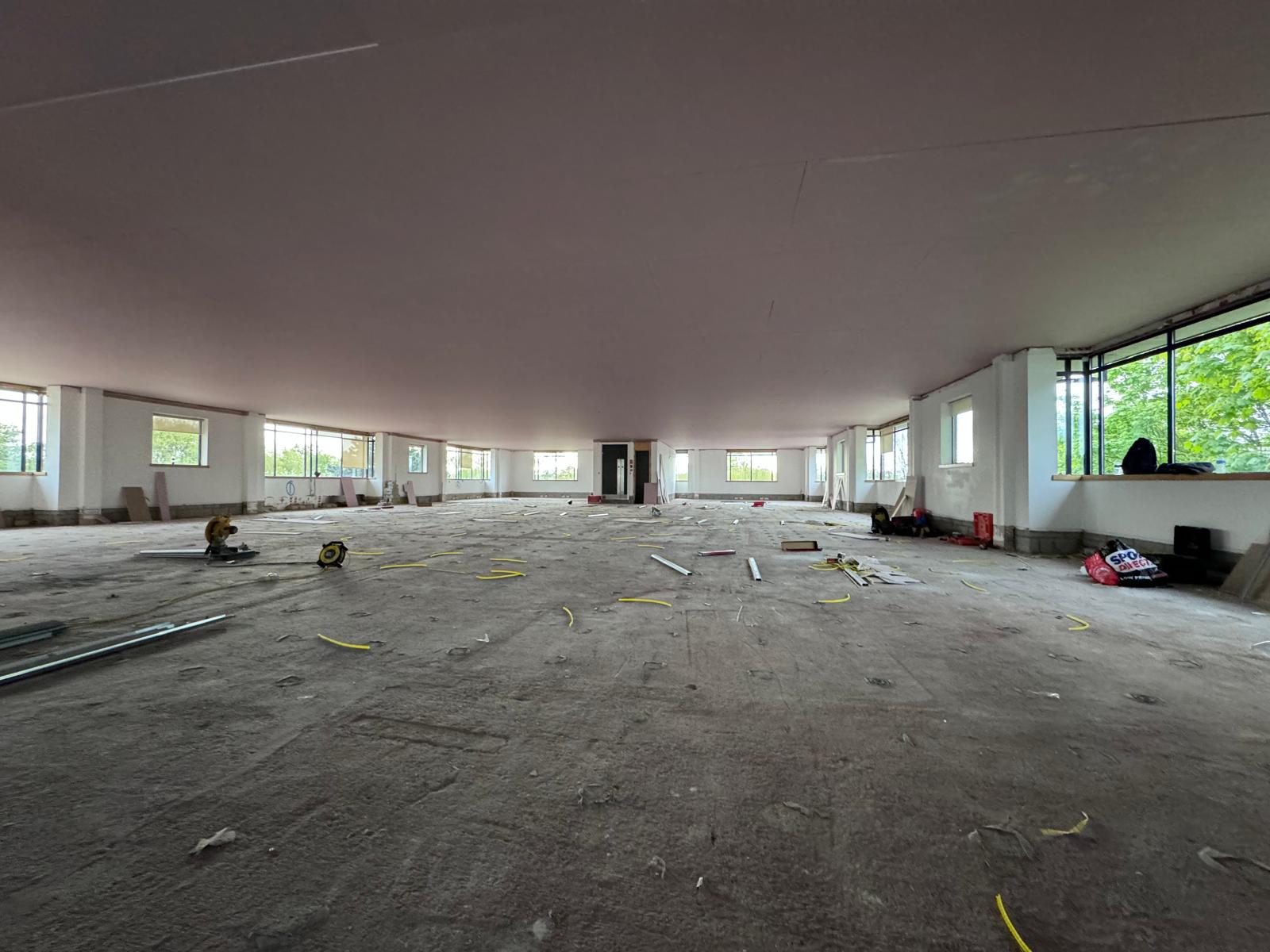 Broad boarded ceiling across an open floor during construction